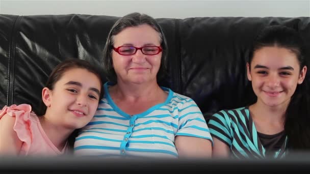 Mujer mayor y niñas viendo la televisión — Vídeos de Stock