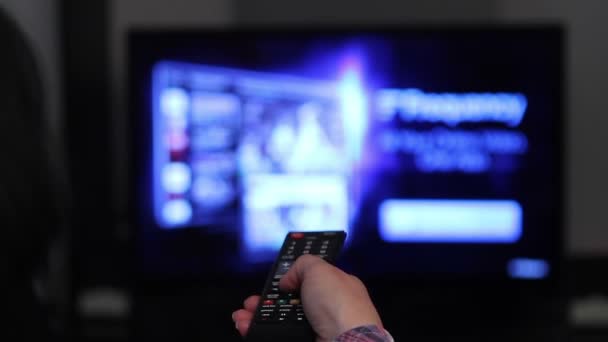 Smart tv och ung kvinna hand trycka på fjärrkontrollen — Stockvideo