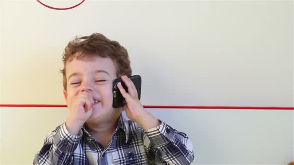 Laughing little boy talking on smartphone — Stock Video