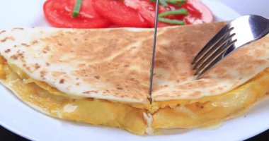 Tabakta peynirli ve domatesli taze tortilla omleti. Sağlıklı kahvaltı konsepti. Dolly 4K çekti.