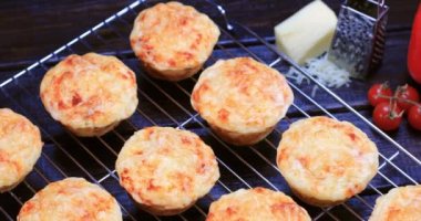 Lezzetli peynirli kekler arka planda sebzelerle birlikte rafta soğutuluyor. Ev yemeği konsepti. Dolly 4K çekti.