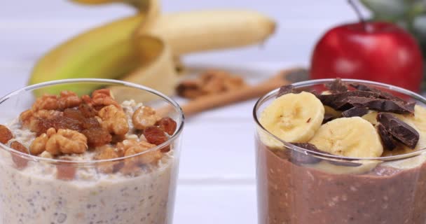 果物粥やバナナリンゴチョコレートと木の背景にナッツと一晩オート麦 健康的な食品朝食と食事のコンセプト ドリーショット4K — ストック動画