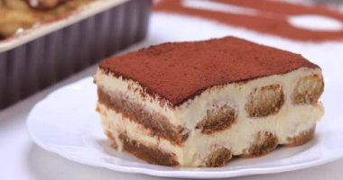 Ev yapımı tiramisu kekini kapat. Bir dilim lezzetli tiramisu servis ediyorum. 4k