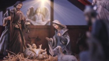 İsa Mesih 'in doğuş sahnesinde atmosferik ışıklar vardı. İsa Mesih 'in doğuş sahnesinde heykelcikler ve ışık parçacıkları vardı. Noel sahnesi. Dolly 4K çekti.