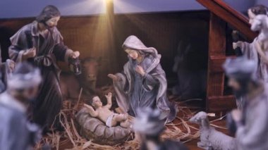İsa Mesih 'in doğuş sahnesinde atmosferik ışıklar vardı. İsa Mesih 'in doğuş sahnesinde heykelcikler ve ışık parçacıkları vardı. Noel sahnesi. Dolly 4K çekti.