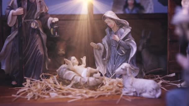 イエス キリスト大気ライトのキリスト降誕の場面 イエス キリスト人形と光の粒子を持つキリスト降誕シーン クリスマスシーン ドリーショット4K — ストック動画
