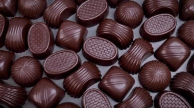 Dark chocolate assorted pralines on black background. Loving chocolate and sweets concept. Dolly shot 4k