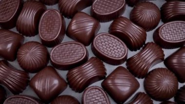 Dark chocolate assorted pralines on black background. Loving chocolate and sweets concept. Dolly shot 4k