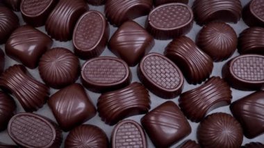 Dark chocolate assorted pralines on black background. Loving chocolate and sweets concept. Dolly shot 4k