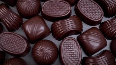 Dark chocolate assorted pralines on black background. Loving chocolate and sweets concept. Dolly shot 4k