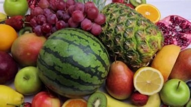 Sağlıklı yemek için çeşitli taze meyveler. Karpuz, ananas, elma, armut, çilek, kivi, limon, portakal, üzüm, yabanmersini, nar, mango, muz. Dolly 4K çekti.