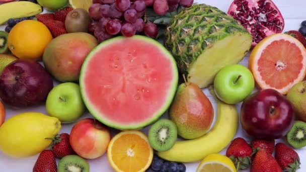 健康的な食事のために新鮮な果物を盛り合わせ スイカ パイナップル リンゴ イチゴ キウイ レモン オレンジ ブドウ ブルーベリー — ストック動画