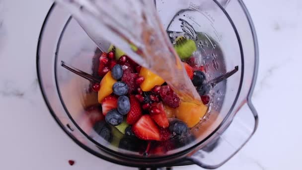 用搅拌机把水倒入新鲜水果中搅拌均匀 为健康饮食准备一杯富含维生素的新鲜饮料 慢动作 — 图库视频影像