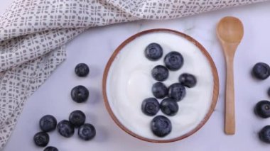 A portion of blueberry yogurt in a wooden bowl ready to be served. Healthy food for dieting concept. Dolly shot 4k