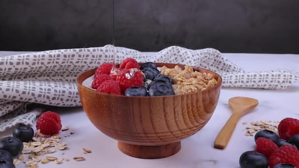 Pouring Honey Yogurt Blueberry Raspberry Oat Flakes Wooden Bowl Ready — Stockvideo