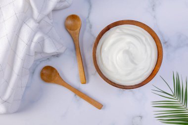 Tahta bir kasede servis edilmeye hazır bir porsiyon Yunan yoğurdu. Diyet konsepti için sağlıklı yiyecek.