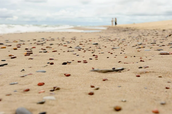 Espuma de ondas em uma praia de seixos . — Fotografia de Stock