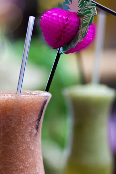 Two colourful alcoholic cocktails and a pink umbrella — Stock Photo, Image