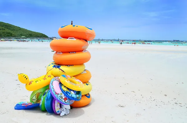 Stack of colorful swimming tubes on the beach — Stock Photo, Image