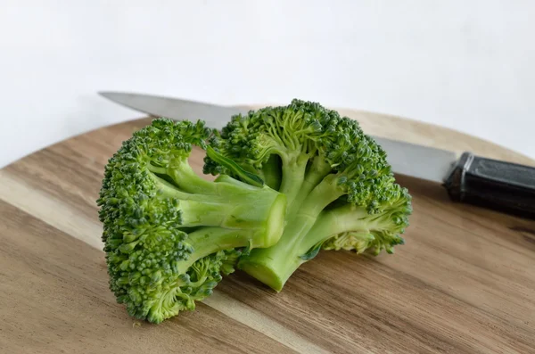 Broccoli vegetali con coltello su taglio di legno — Foto Stock