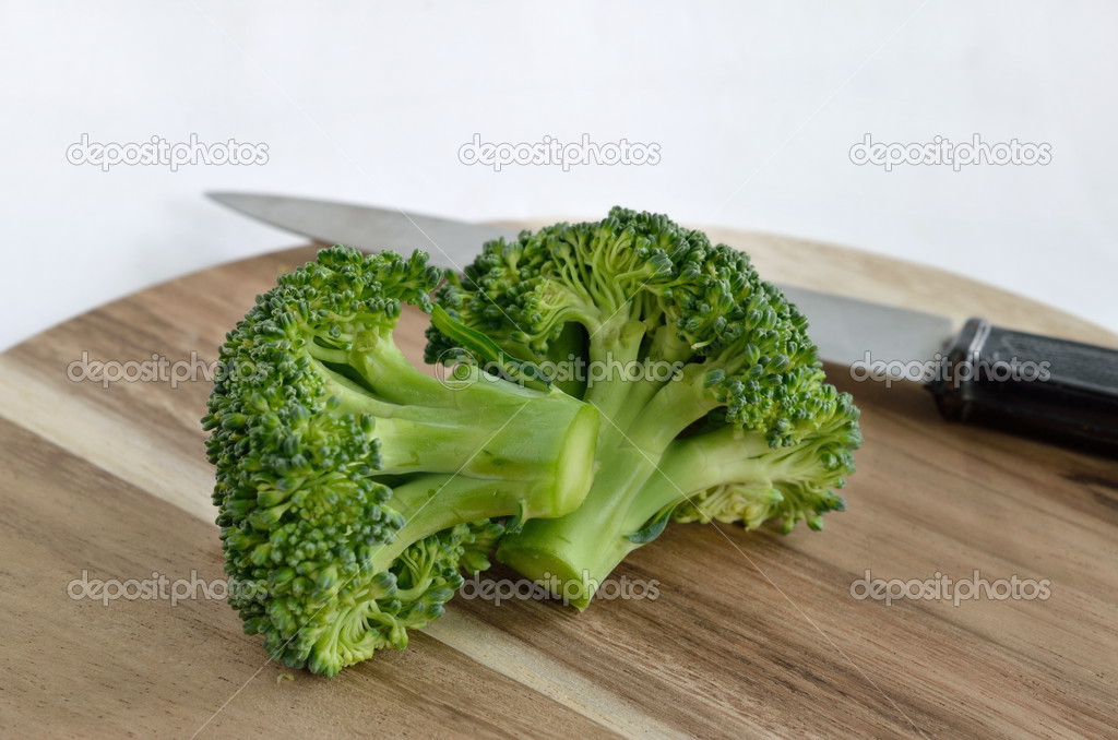 Broccoli vegetable with knife on wooden cutting