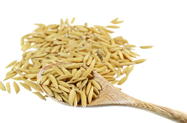 Arroz con cáscara y cuchara de madera aislada en blanco . — Foto de Stock