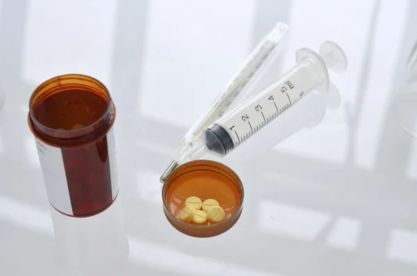 Таблетки с пузырьком от таблеток и шприцем — стоковое фото