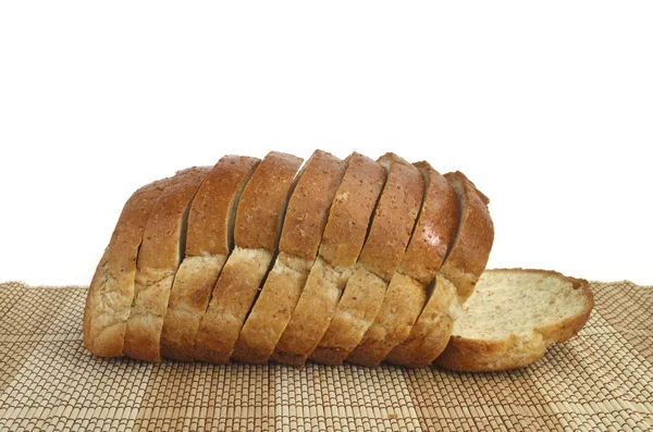 Pão de trigo integral fatiado em madeira — Fotografia de Stock