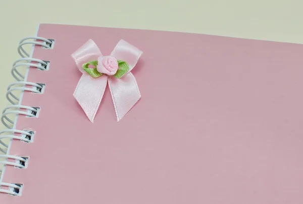 Notebook and pink ribbon bow — Stock Photo, Image