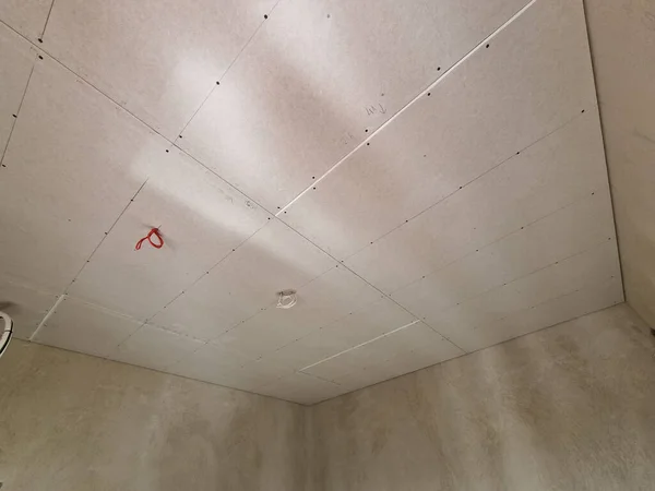 Drywall plaster sheets fixed on ceilings on the construction site