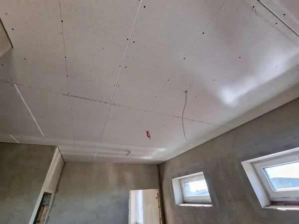 Drywall plaster sheets fixed on ceilings on the construction site