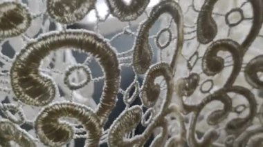 Penceredeki perde rüzgarla hafifçe hareket etti. Beyaz perde tülleri rüzgardan hareket eder.