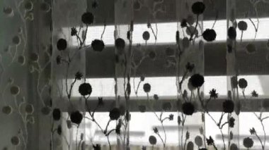 Penceredeki perde rüzgarla hafifçe hareket etti. Beyaz perde tülleri rüzgardan hareket eder.