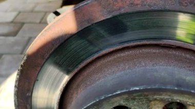 Old brake disc. Car disc brake repair. Vehicle service. Replacing parts by a mechanic