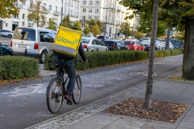 Varşova Polonya; 2 Ekim 2022: Glovo şirketinden bisikletli bir adam. Glovo binicisi, bisikletli teslimatçı sipariş verecek. Glovo uygulama dağıtım servisi 