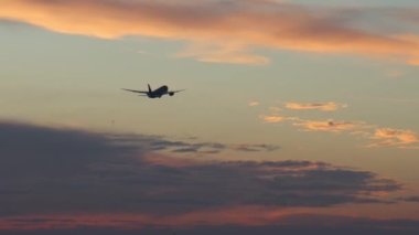Uçak yolculuğu konsepti. Büyük bir yolcu uçağı gün batımının arka planında havalanır.