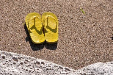 plaj kum üzerine sarı flip flop