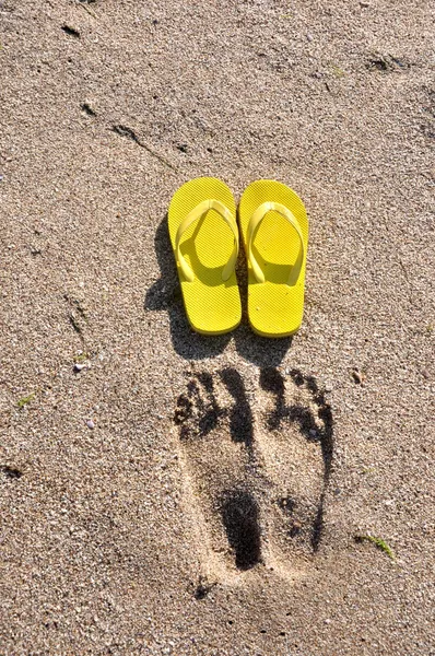 Tongs jaunes sur le sable de la plage — Photo