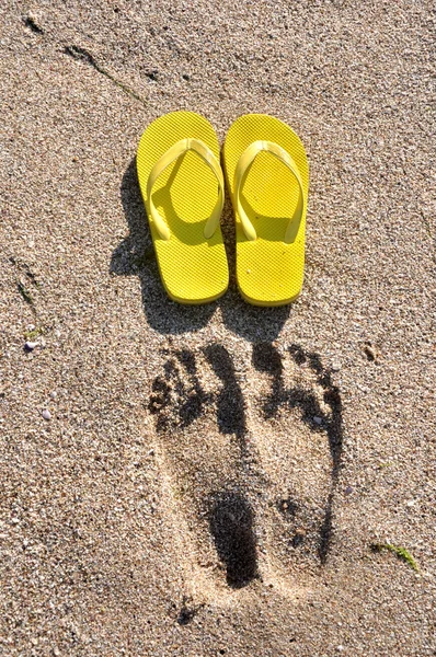 Tongs jaunes sur le sable de la plage — Photo