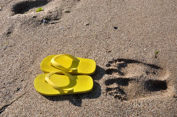 Infradito gialle sulla sabbia della spiaggia — Foto Stock