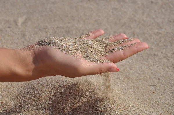 Lik sand genom fingrarna Royaltyfria Stockfoton