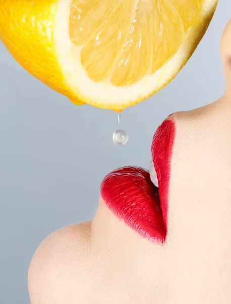 Mooie lippen en vallende druppel citroen — Stockfoto