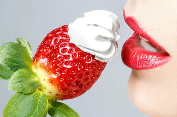 Szép piros ajkak és ízletes eper tejszínhabbal — Stock Fotó