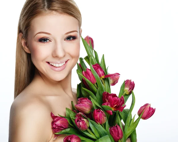 Schöne lächelnde blonde Frau mit Blumen — Stockfoto