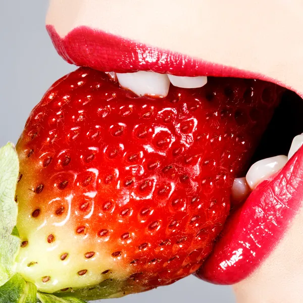 Mooie sappige aardbeien en vrouwelijke lippen — Stockfoto