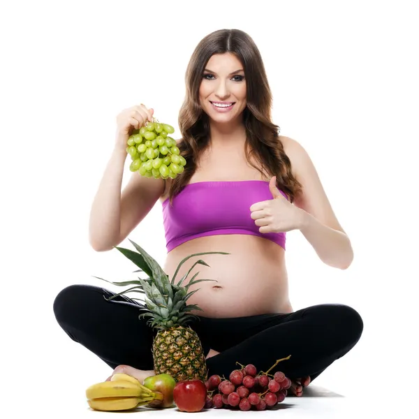 Mujer embarazada sonriente con frutas —  Fotos de Stock