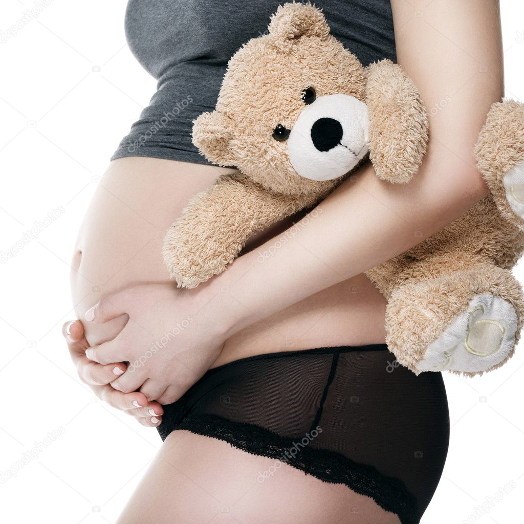 Belly of a pregnant woman with a plush toy