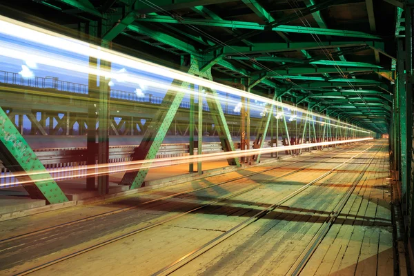 Tramvaj v provozu na mostě v noci — Stock fotografie