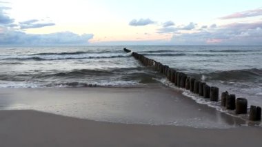 Baltık Denizi ve gün batımında dalgakıran
