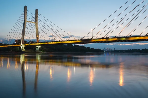 Ponte de suspensão à noite e refletida na água — Fotografia de Stock